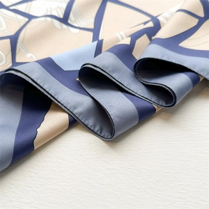 Detailed close-up of blue geometric twill silk scarf showing fine texture and hemmed edges