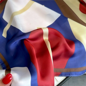 Close-up of geometric pattern silk scarf with sleek texture and vibrant color blocking