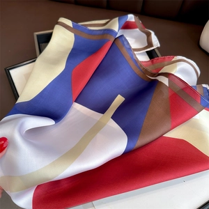Macro shot of geometric color-block silk scarf texture with detailed stitching edges