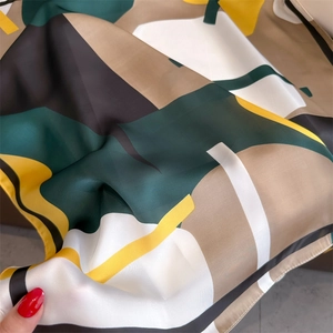 Detail of geometric pattern scarf showing smooth satin texture and hand-rolled edges