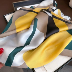 Geometric color-block silk scarf in yellow and green with a glossy satin finish texture
