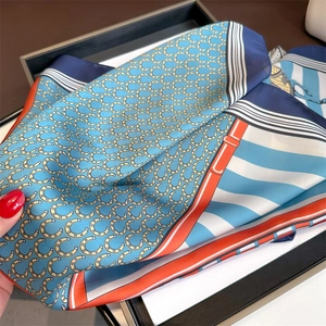Macro detail of silk scarf showing glossy texture and elegant horse bit pattern