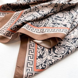 Detail of rose print silk scarf featuring baroque scrolls and Greek key borders