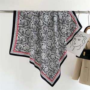 Detail of baroque silk scarf with Greek key patterns and elegant red border accents