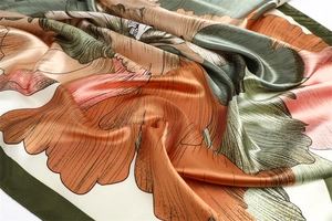 Detailed view of floral silk scarf with vintage orange and green gradient patterns