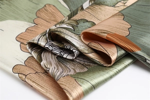Close-up of floral silk scarf showing smooth texture and elegant hand-painted patterns