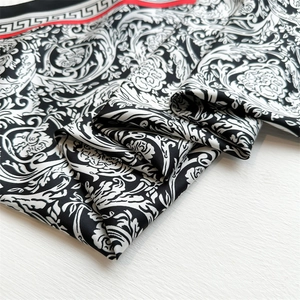 Close-up of Baroque pattern silk scarf with black white scrolls and red border detail