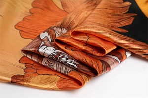 Close-up of vibrant floral satin scarf showing silk texture and glossy fabric folds