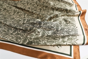 Close-up of paisley pattern satin square scarf with dark green and brown borders