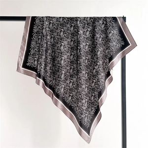 Close-up of black paisley printed satin scarf with elegant silver cashew flower patterns