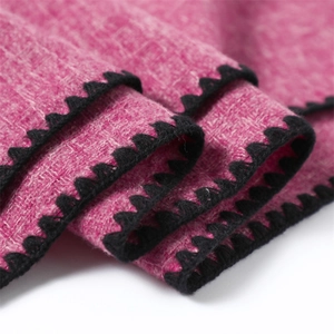 Macro shot of rose pink cashmere-feel shawl with black scalloped edge detail