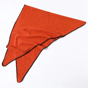 Detail of orange triangle scarf featuring textured weave and black crochet edge stitch