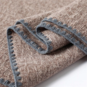 Detailed macro view of brown checkered cashmere-feel scarf with gray crochet scalloped edges