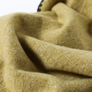 Macro shot of yellow cashmere-feel scarf fabric with fine grid texture and wavy hem