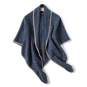 Detailed view of dark blue knitted shawl with beige scalloped crochet lace edges