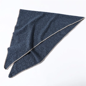 Close-up of dark blue cashmere-like triangular scarf with beige scalloped edge detail