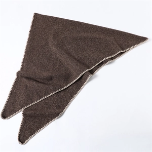 Detail of dark brown triangle scarf showing fine knit texture and beige scallop stitched edges