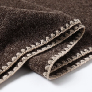 Detail of dark brown faux cashmere scarf with cream whipstitch crochet edging texture