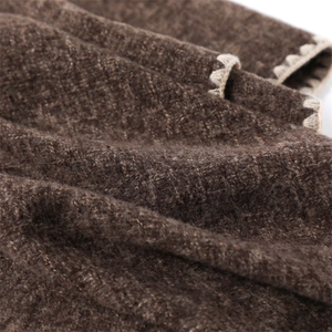 Detailed macro view of dark brown cashmere-like scarf with scalloped edge stitching