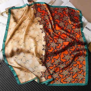 Detail of silk-texture square scarf with orange maple leaf print and dark green border