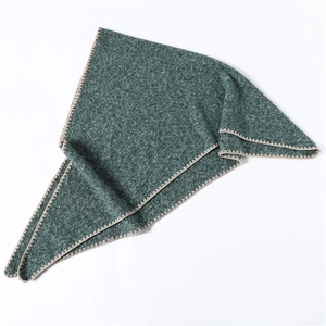 Detail of dark green knit triangle scarf featuring beige contrast zigzag edge stitching