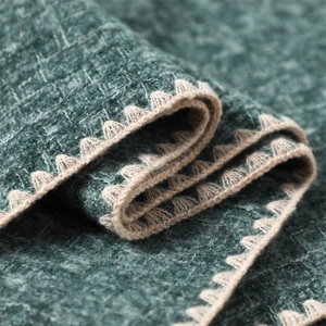 Close-up of dark green cashmere scarf with white crochet wave edges and thick texture