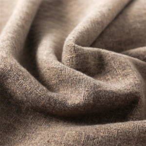 Detailed view of the thick faux cashmere fabric with warm brown-grey texture and fringe