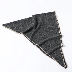Detailed view of dark grey cashmere-feel triangle scarf with beige zigzag edge stitching