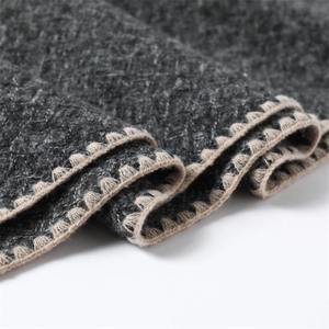 Detail of dark grey and beige cashmere-like knit scarf with diamond texture and crochet edge