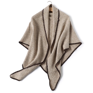 Detail of beige cashmere-like knit shawl showing zigzag stitching and woven texture