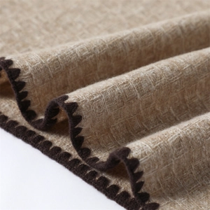 Detail of solid cashmere scarf showing textured knit and scallop crochet edge trim