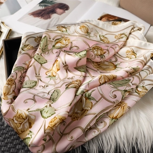 Vue détaillée d'un foulard en soie rose avec roses jaunes sur fond de fausse fourrure