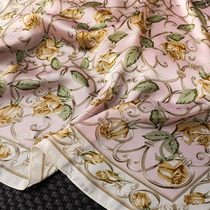 Gros plan du foulard en satin rose avec roses jaunes et texture soyeuse élégante