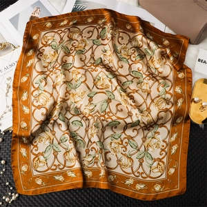 Détail d'un élégant foulard carré en satin avec roses jaunes et motifs vintage