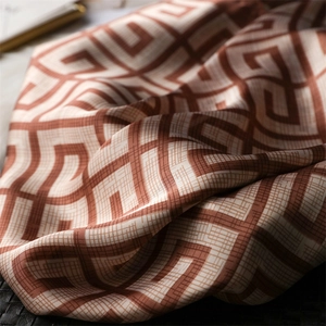 Vue détaillée d'un foulard carré en satin de luxe avec motif géométrique et texture soie