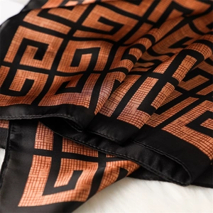 Détail d'un foulard carré en soie avec motif géométrique 4G et texture soyeuse