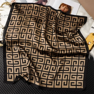 Détail d'un foulard carré effet soie avec motifs géométriques et fini satiné brillant