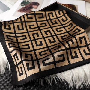 Gros plan détaillé d'un foulard en soie de luxe avec logo géométrique en noir et or