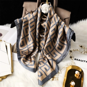 Élégant foulard en soie 70cm à motif géométrique champagne drapé sur un sac à main de luxe