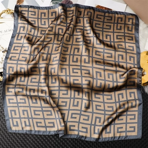 Vue détaillée du motif de labyrinthe géométrique et de la texture soyeuse du foulard carré