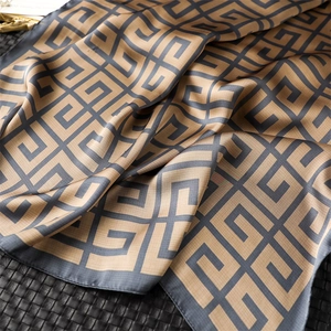 Détail d'un foulard en soie avec motif géométrique de labyrinthe et texture satinée