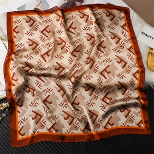 Détail macro du foulard carré soyeux avec imprimés géométriques rétro et texture lisse
