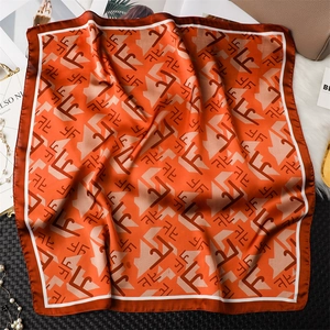 Détail d'un foulard en soie à motifs géométriques avec accessoires de luxe