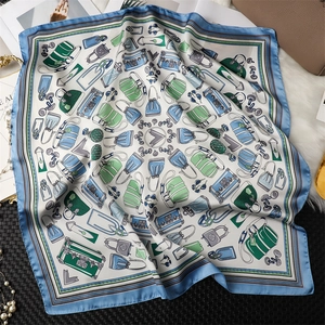 Detailed view of square silk scarf with vintage travel trunks and light blue border