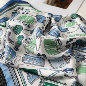Detailed close-up of a vintage silk scarf with elegant fashion bags and suitcase prints