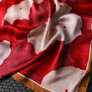Elegant camellia floral silk scarf with red and gold patterns on a textured black background