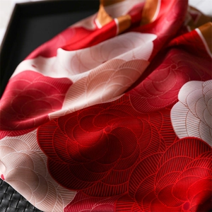 Red camellia floral print silk square scarf with elegant satin finish and draped texture