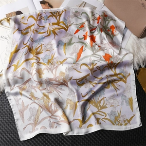Detailed close-up of silk scarf showing elegant iris floral patterns and satin texture