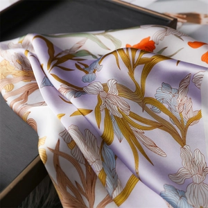 Close-up of Iris floral print silk scarf featuring elegant purple and orange patterns
