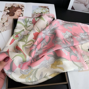 Detail of iris floral print silk scarf with hand-rolled edges in soft pink and beige